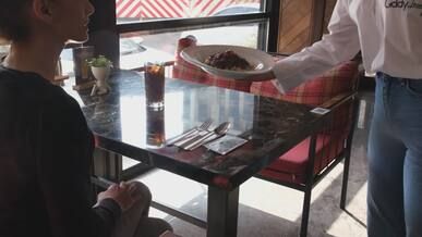 waitstaff serves meal at cozy restaurant table