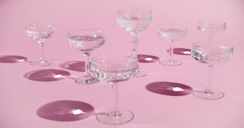 Différents Types De Verres à Cocktail En Cristal Sur Une Surface Rose