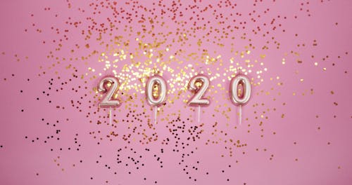 Glitters Of Gold Confetti Over A Pink Surface