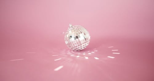 A Small Mirror Ball Bouncing Off Squared Light Reflections In The Pink Surface