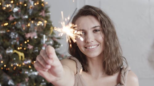 A Woman Holding A Lighted Stick Sparkle