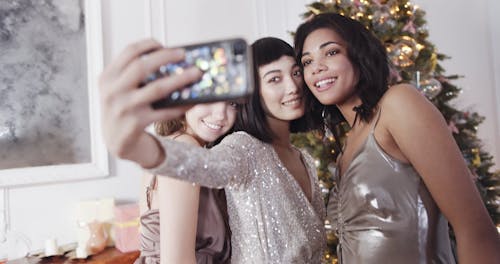 A Group Of Women Grouping Together To Take A Group Selfie Using A Cellphone