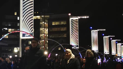 People On A Walking Street In Wembley Park With Neon Lights Trail