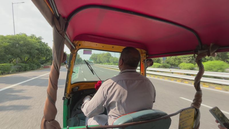 Wide angle shot of an auto rikshaw driver on roads of Delhi India Free ...