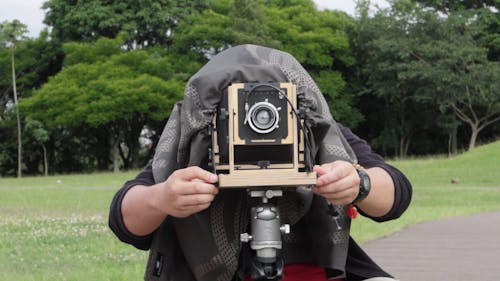 A Person Preparing A Classic Camera Ready For Use