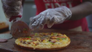 delicious fresh pizza being carefully sliced