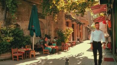 sunny alleyway with cafes and pedestrians
