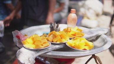 fresh mango chunks on street vendor tray
