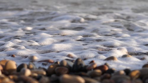 Sea Waves Kissing The Cobblestones Piled In A Seashore