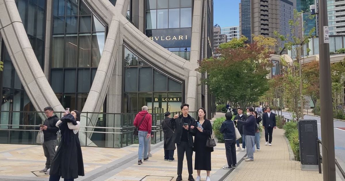 people walking by bulgari store in urban setting 34575153
