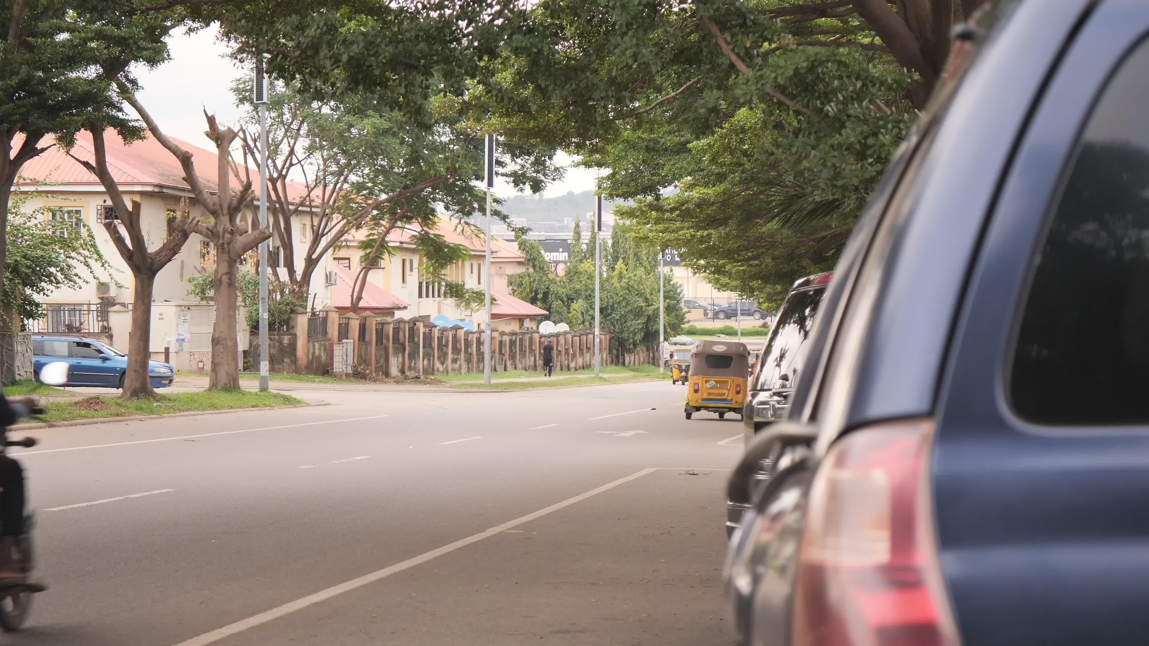 quiet urban street with passing vehicles 34688097