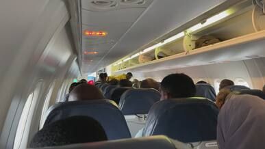 passengers seated in airplane cabin interior view