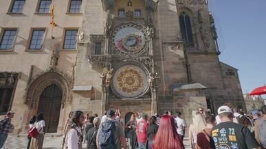tourists gather at prague astronomical clock