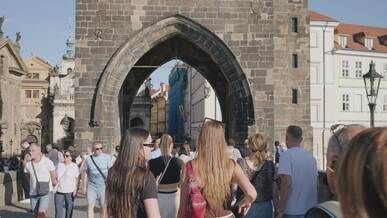 tourists walking through charles bridge archway