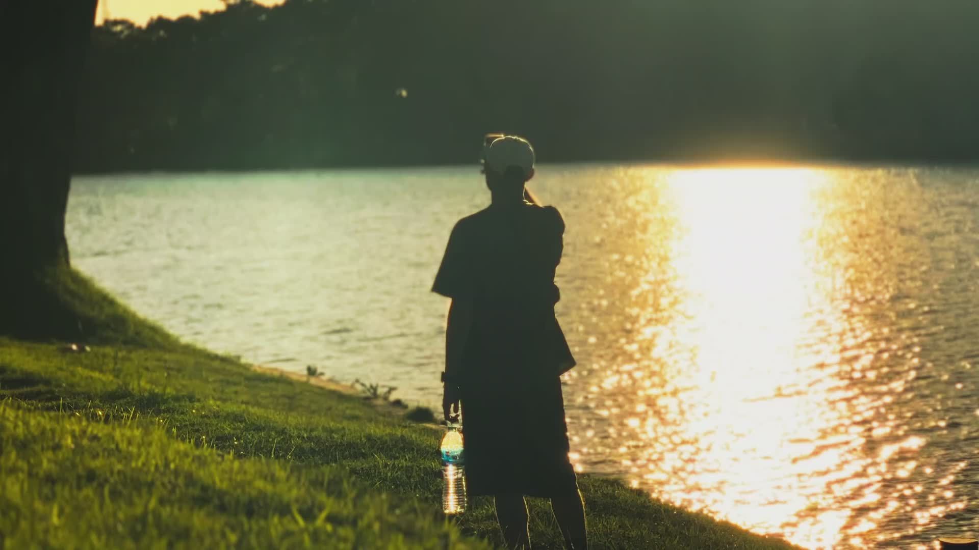 Silhouette of Person Walking by Lakeside at Sunset Free Stock Video ...