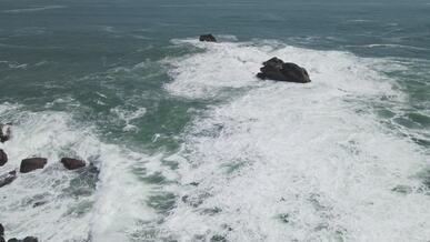 aerial view of crashing waves on rocky shoreline