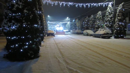 帶有掃雪機的卡車清理積雪覆蓋的街道