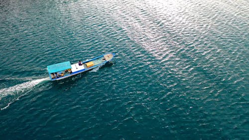 People Riding a Blue Boat