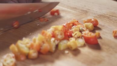 chef chopping fresh chili peppers close up