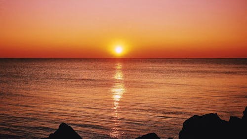 从多岩石的海岸海上地平线的日落美景