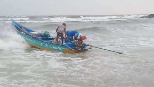 A Fishing Boat Floating Through Strong Waves Towards The Open Sea