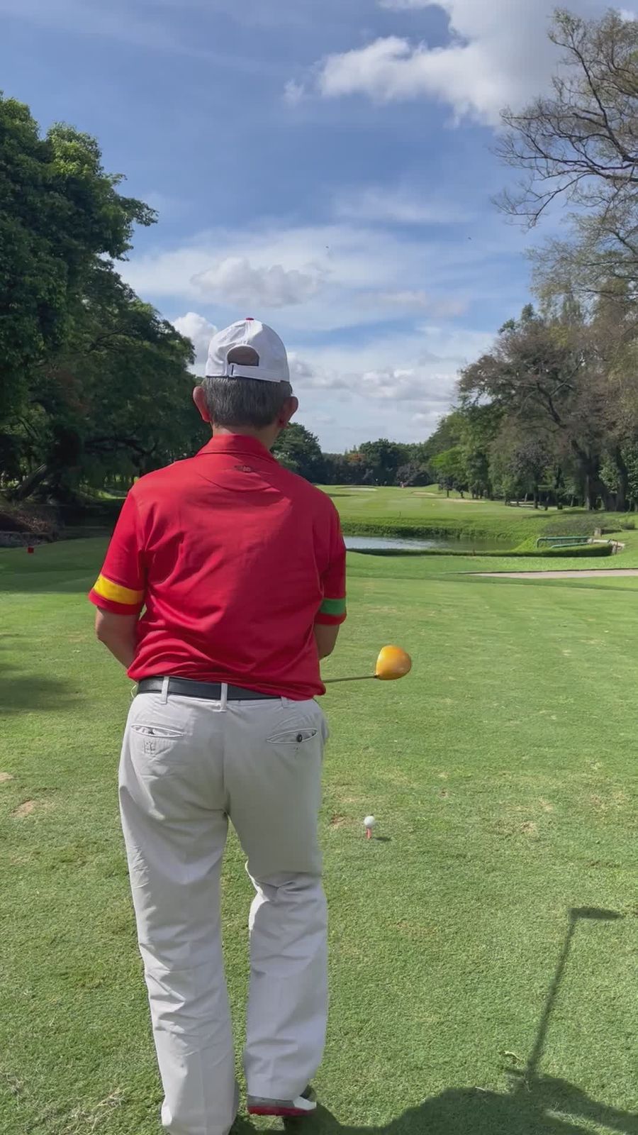 Golfer mid-swing on a sunny course