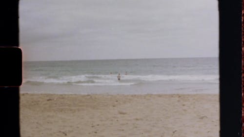 复古风格在海滩上游泳的人的镜头