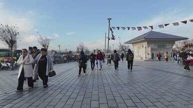 people walking in a sunny public square