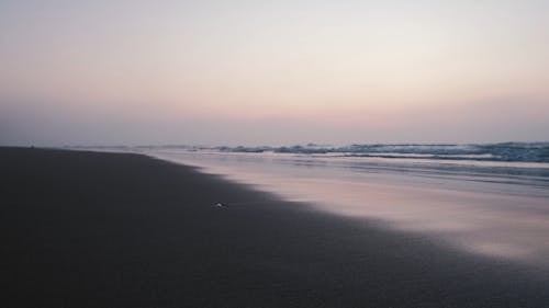 日没時に岸に打ち寄せる波