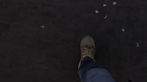 A Person Walking On The Seashore Leaving Foot Prints In The Sand