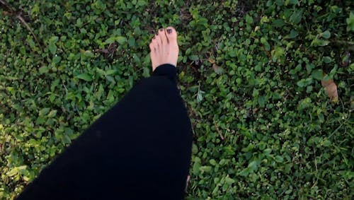 A Woman Feet Walking On Grass Barefooted