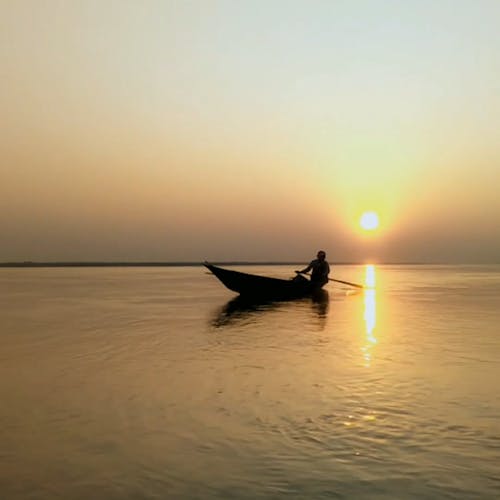 Silhueta De Um Homem Em Um Barco Ao Pôr Do Sol