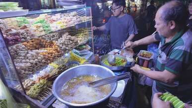 bustling night street food vendor cooking skewers