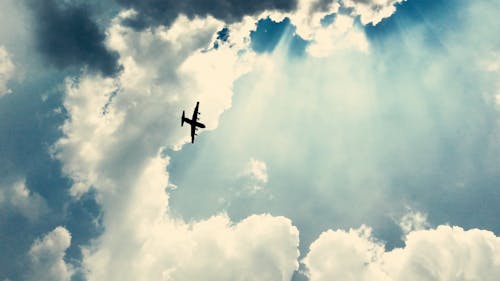 空気中の厚い雲の形成の下を飛んでいる飛行機