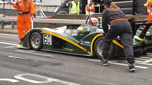 Slow Motion Footage Of People Looking Into Race Cars On Display Outdoor ...