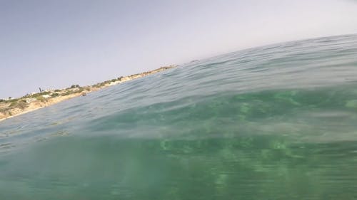 A Person Swimming Over And Under The Sea Water