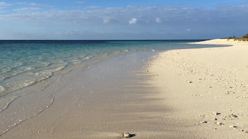 The Sea Waves Kissing The White Sand Of An Island Beach