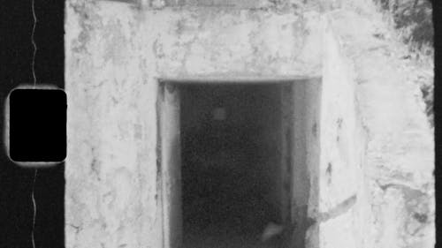 Black and White Footage of a Person Entering a Scary Passageway