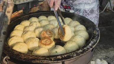 street vendor cooking delicious steamed buns