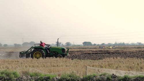트랙터 쟁기를 사용하는 농부가 종자 심기를 위해 농장 토지를 준비