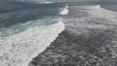 aerial view of ocean waves on a tropical coastline