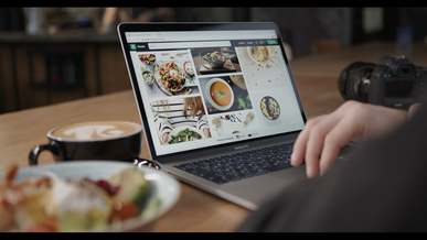 a person scrolling on a laptop