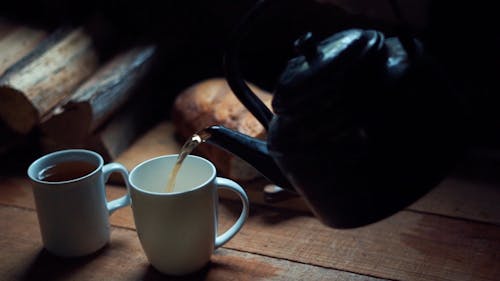 Наливание горячего чая в чашки на завтрак