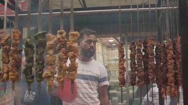 street vendor grilling kebabs at iftar market