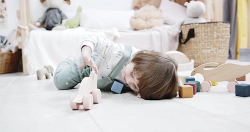 A Kid Playing With Wooden Toys In The Floor Of A Playroom