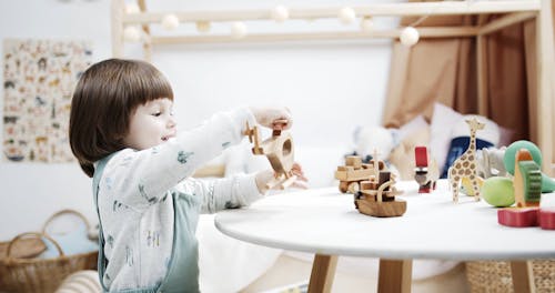 A Little Girl Playing With Wooden Toys