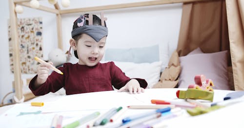 A Child Choosing Coloring Pens Of Different Color In Making A Drawing