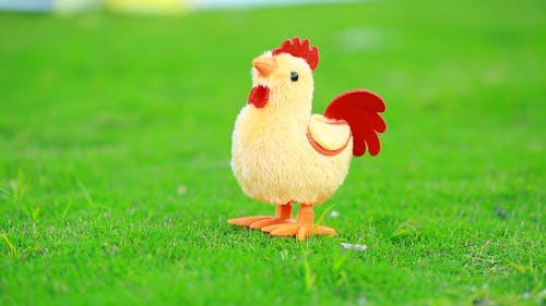 A Chicken Image Toy Hopping On A Lawn Grass