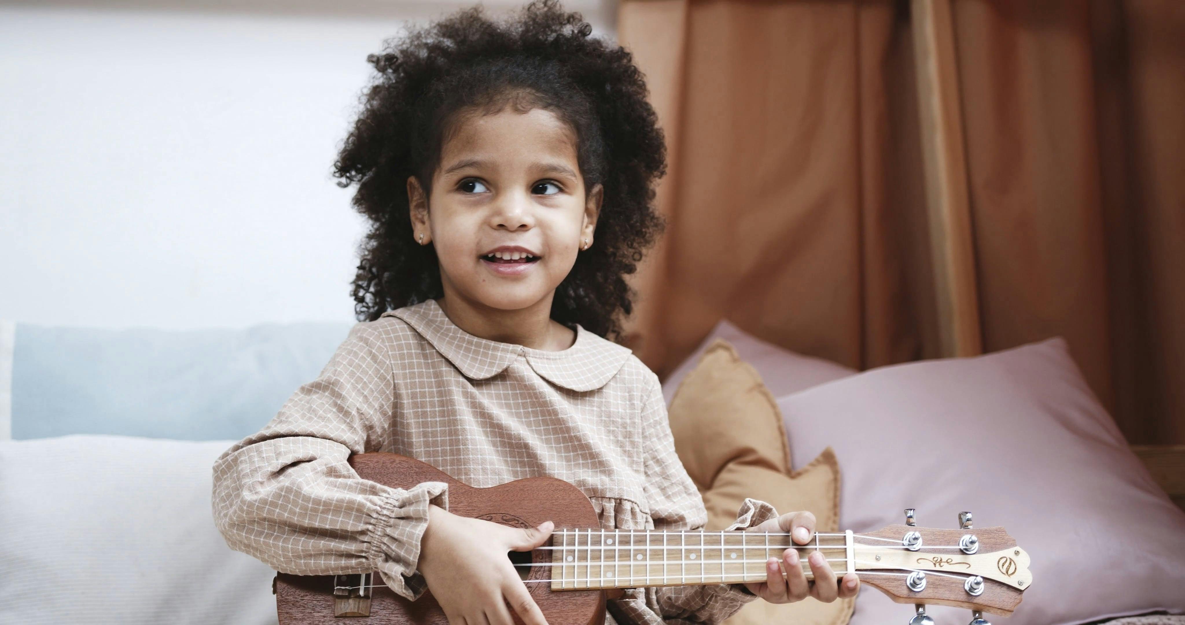 A Young Girl Playing The Ukelele · Free Stock Video