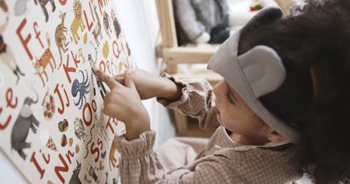 A Girl Identifying The Image Drawings On An Alphabet Table